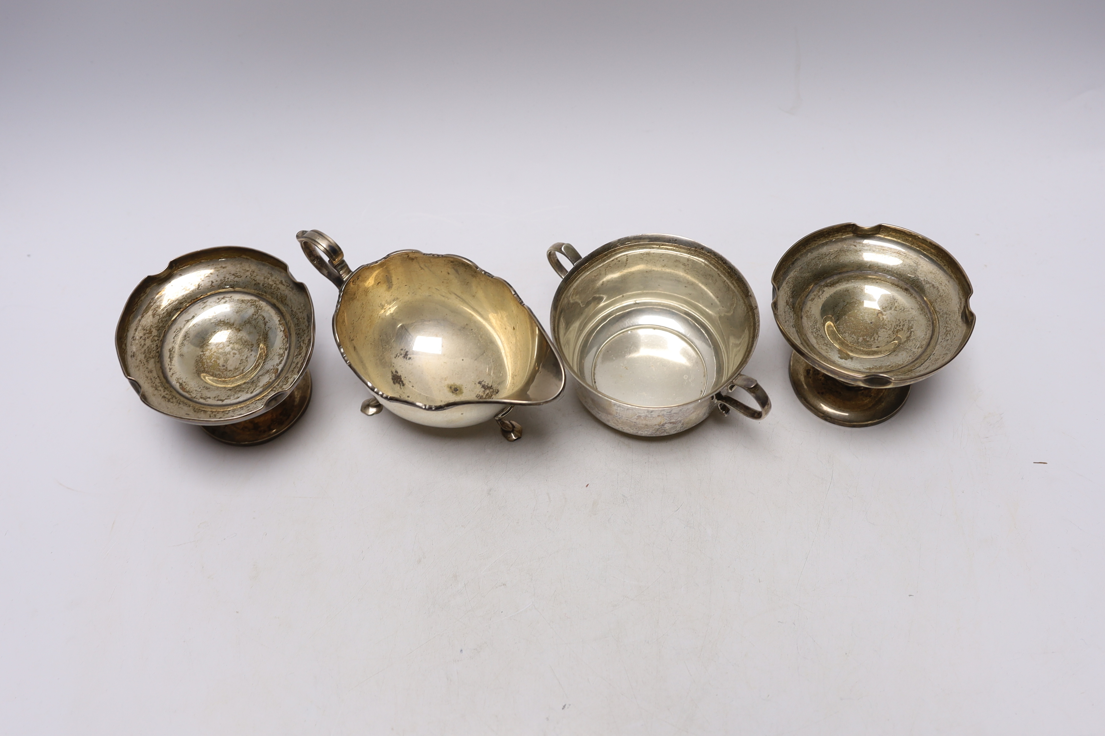 An Elizabeth II silver sauceboat, by Harrods Ltd, a silver two handled bowl and a pair of silver mounted pedestal bonbon dishes.